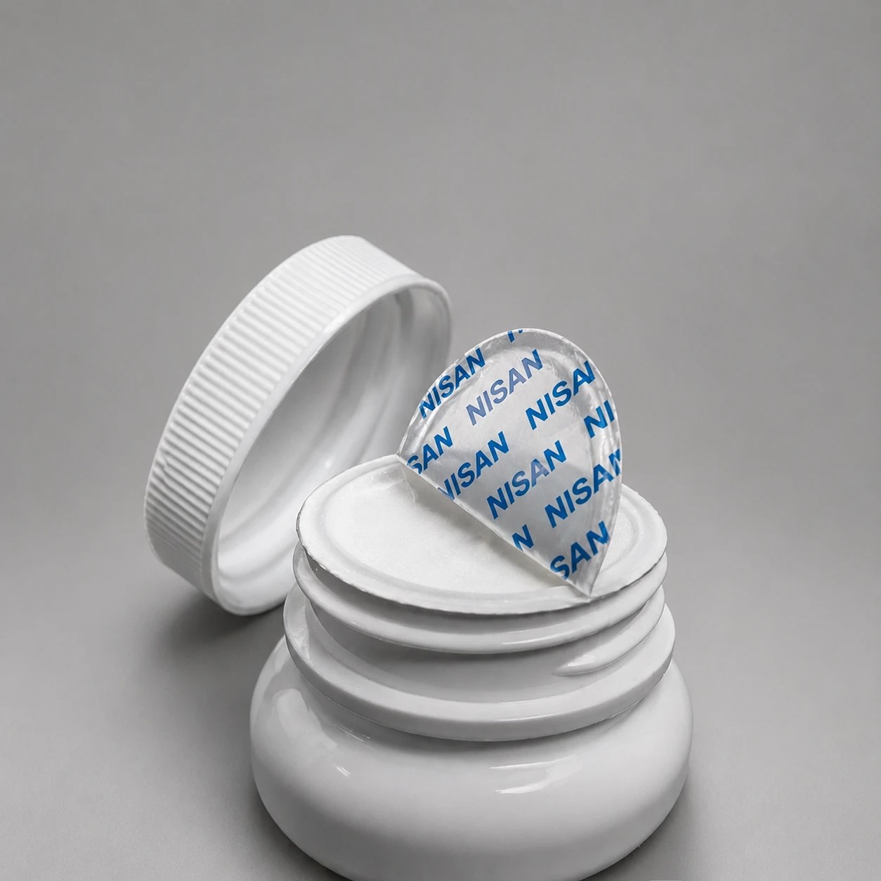 Jar sealed with an induction liner, cap with backing disc beside it